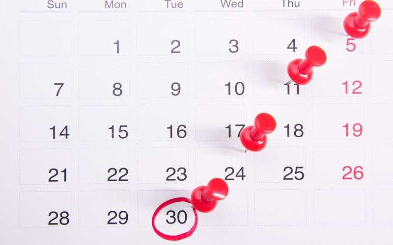 A calendar with pins marking the days of a cycle